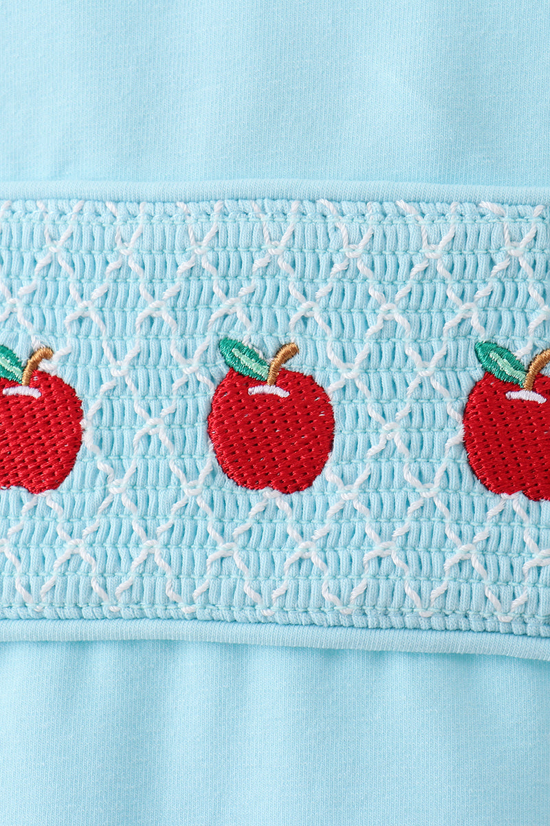 Light blue smocked panel with red apple appliques