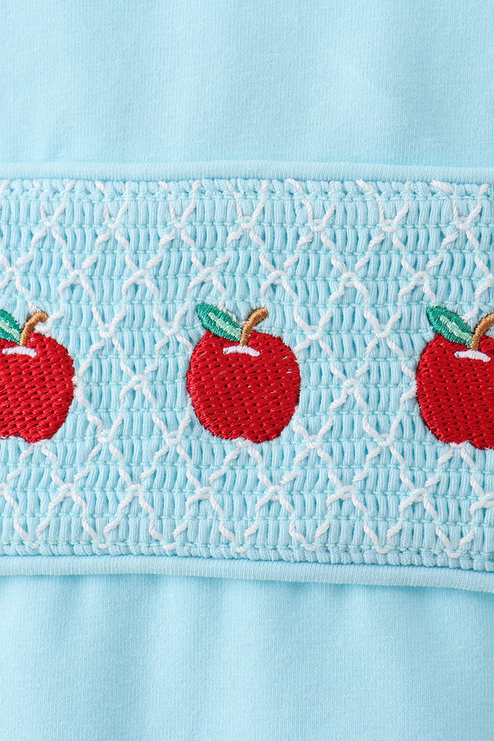 Light blue smocked panel with red apple appliques