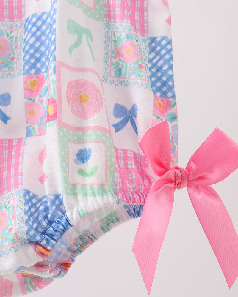 Patchwork fabric with colorful patterns and a pink bow on a white background