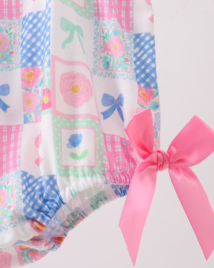 Patchwork fabric with colorful patterns and a pink bow on a white background