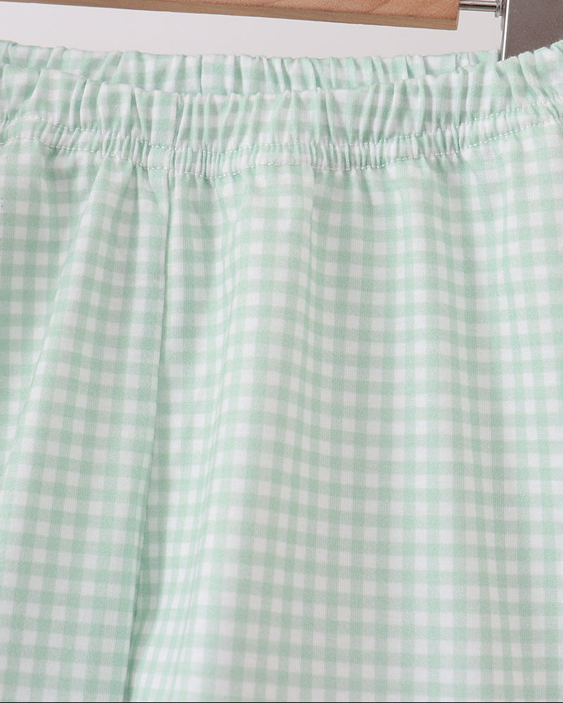 Light sage gingham shorts with elastic waistband and gathered ruffle hem
