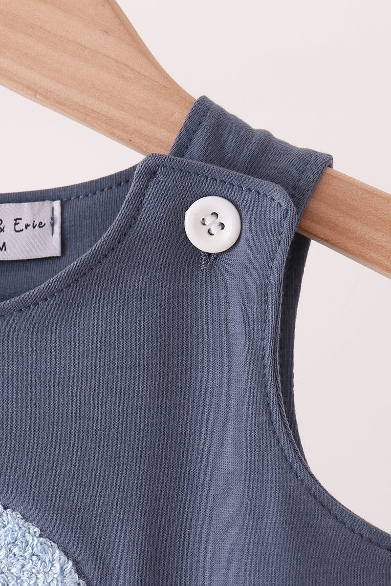 Navy sleeveless romper with round button at shoulder and curved neckline