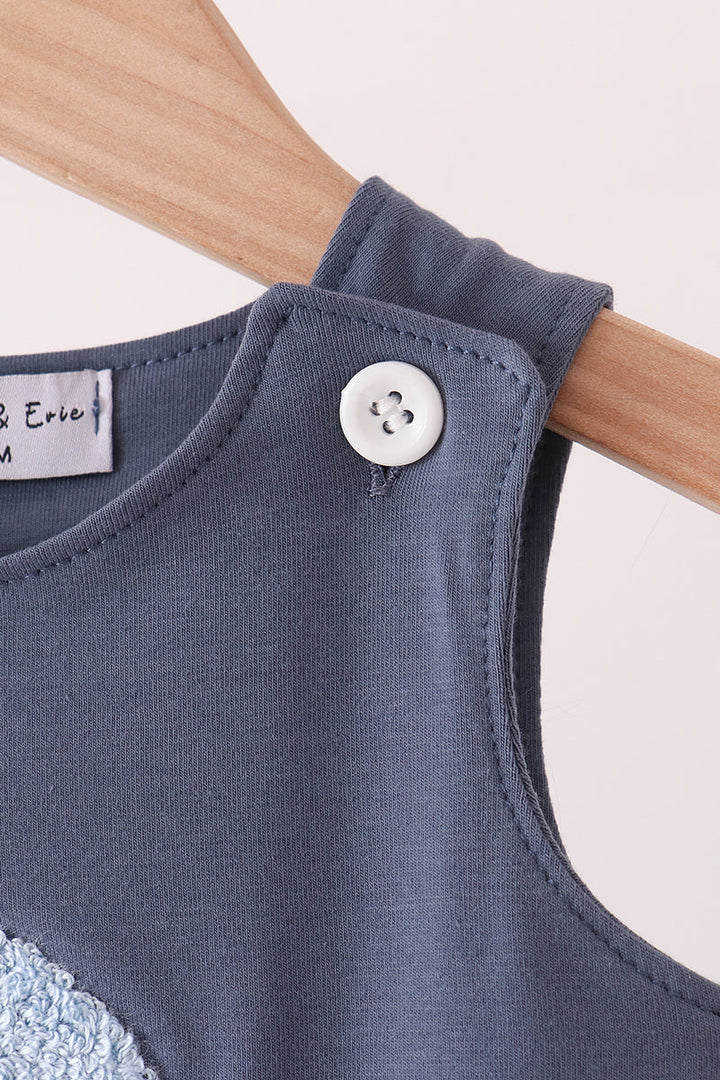 Navy sleeveless romper with round button at shoulder and curved neckline