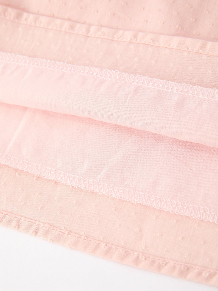 Pink dress hem closeup with layered ruffle and lace trim