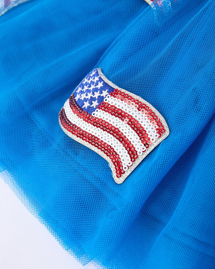 Blue fabric with a beaded American flag patch on a white background