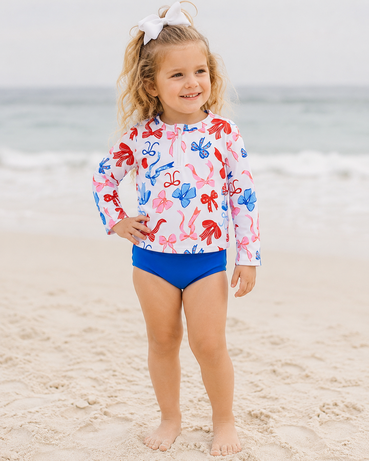Young girl on beach wearing 4th of July Boutique Swimsuit