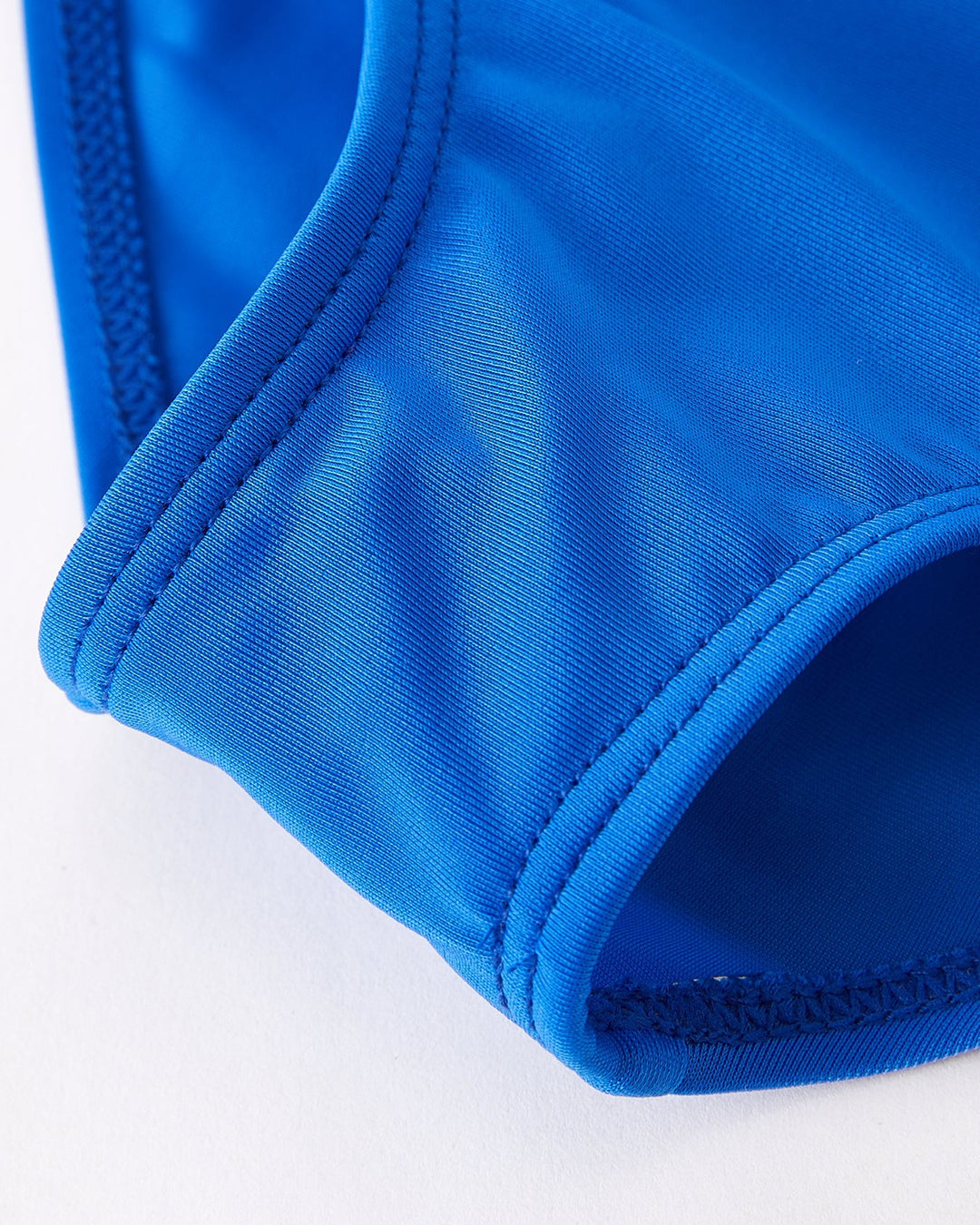 Close-up of a blue swimsuit bottom on a white background