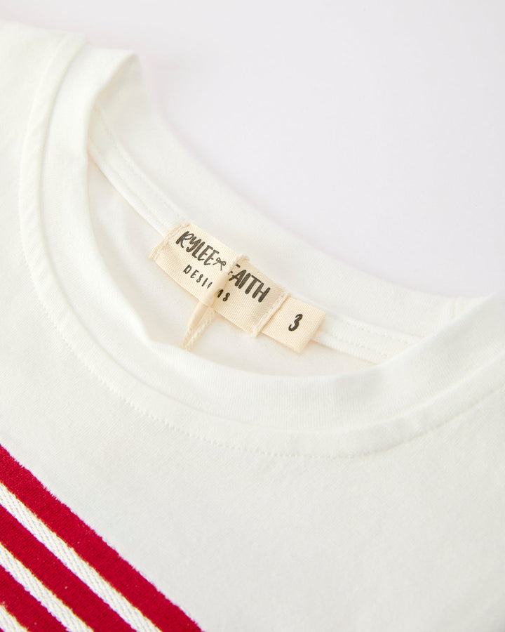 Close-up of a white shirt with red stripes and a label on a white background