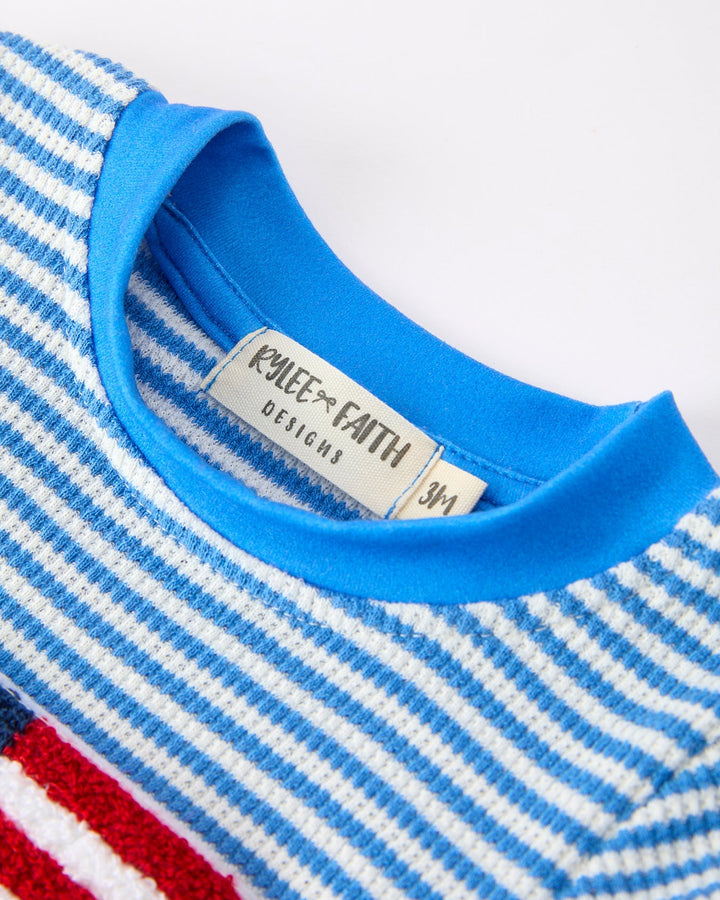 Close-up of a blue and white striped shirt with a brand label on a white background