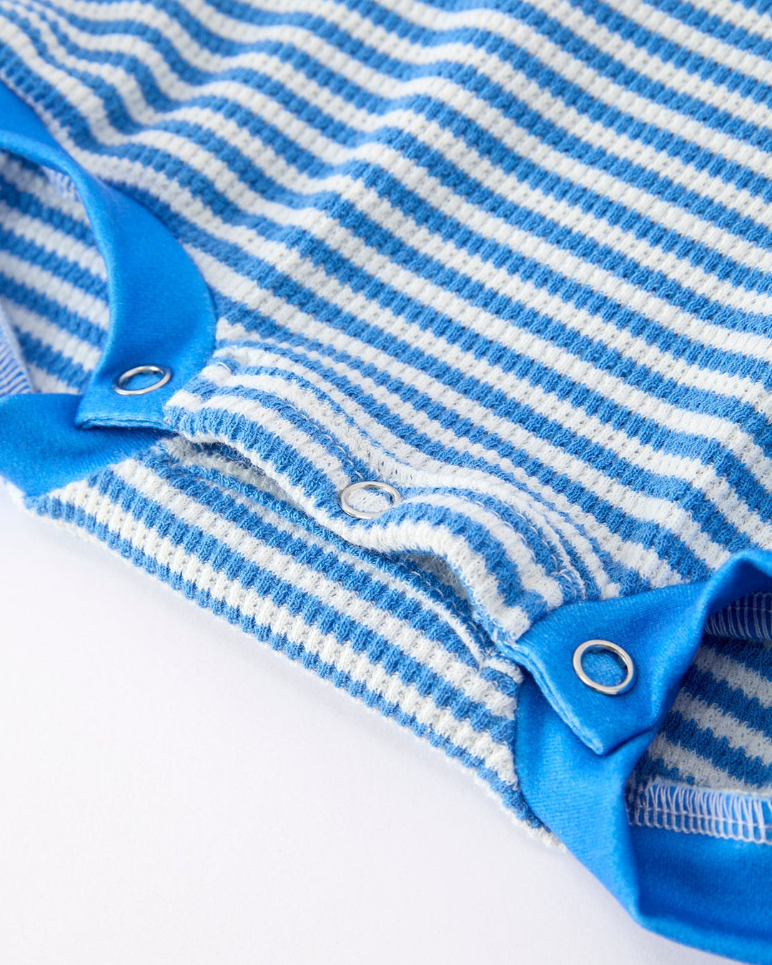 Close-up of a blue and white striped baby romper with a plain background