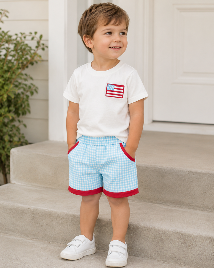 Young boy standing outside wearing 4th of July Flag Plaid Shorts Set