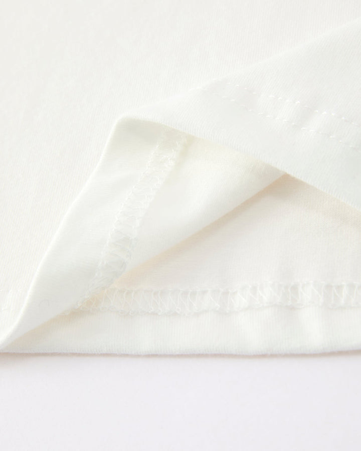 Close-up of a white fabric with a subtle pattern on a light gray background