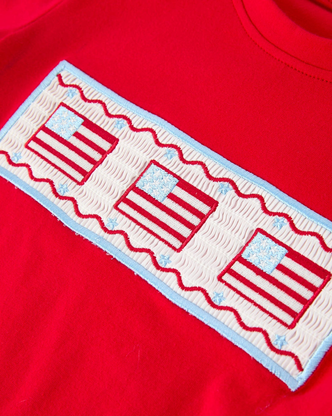 Red  shirt with a decorative patch featuring red and white stripes on a red background