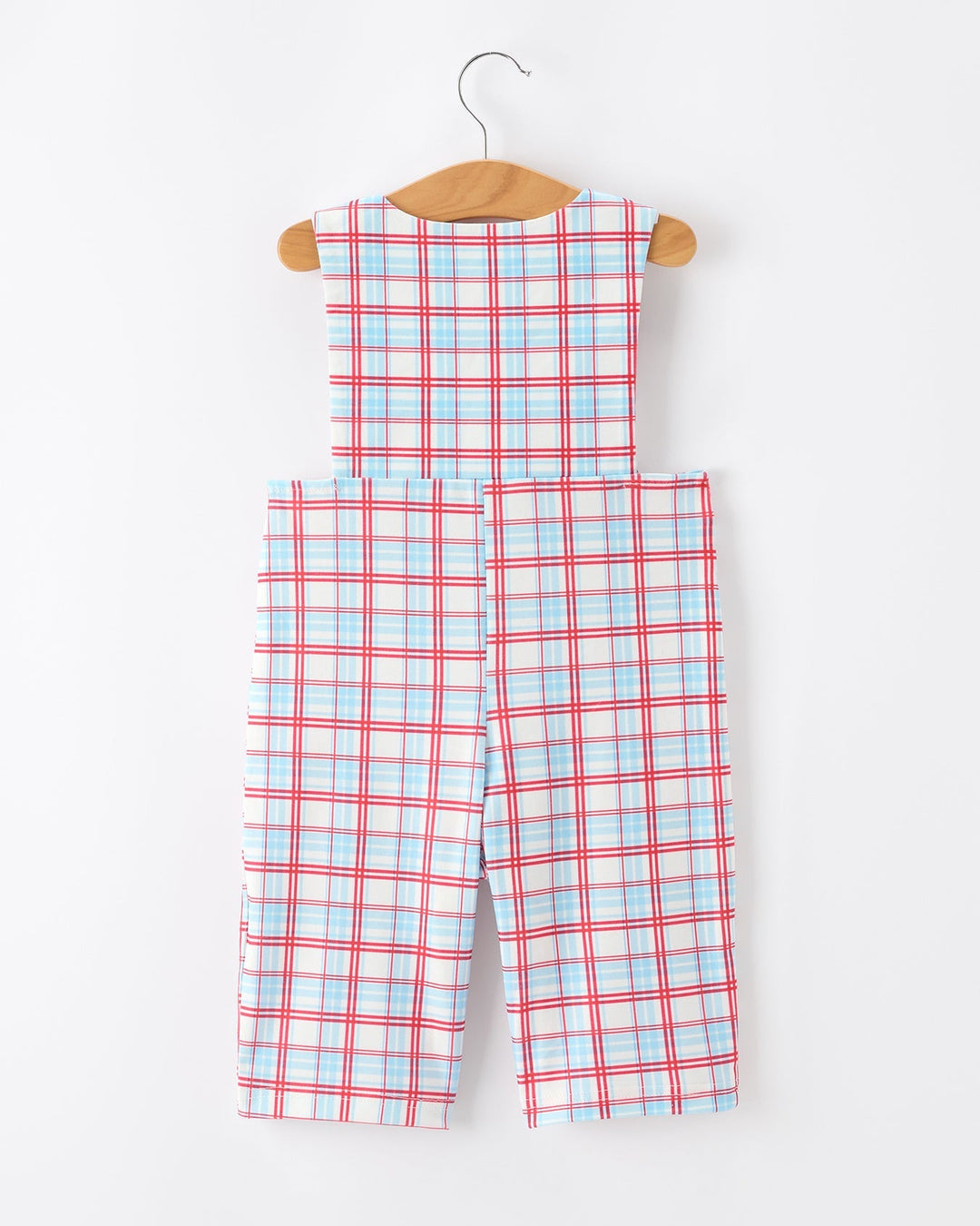 Plaid jumpsuit on a hanger against a white background