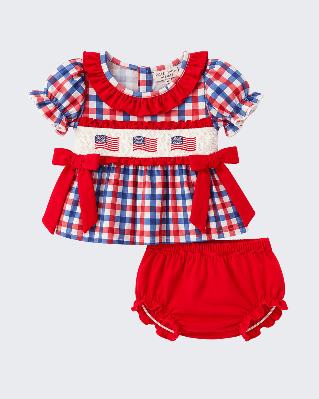 Children's red, white, and blue checkered outfit with ruffled top and matching bloomers on a light gray background.