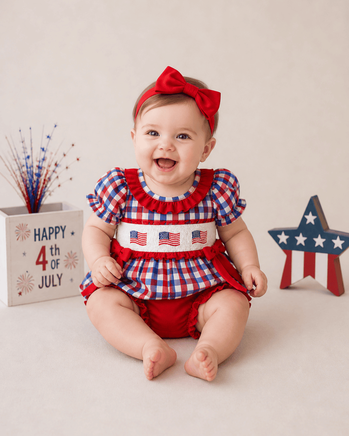 Baby wearing a red, white, and blue outfit with a &