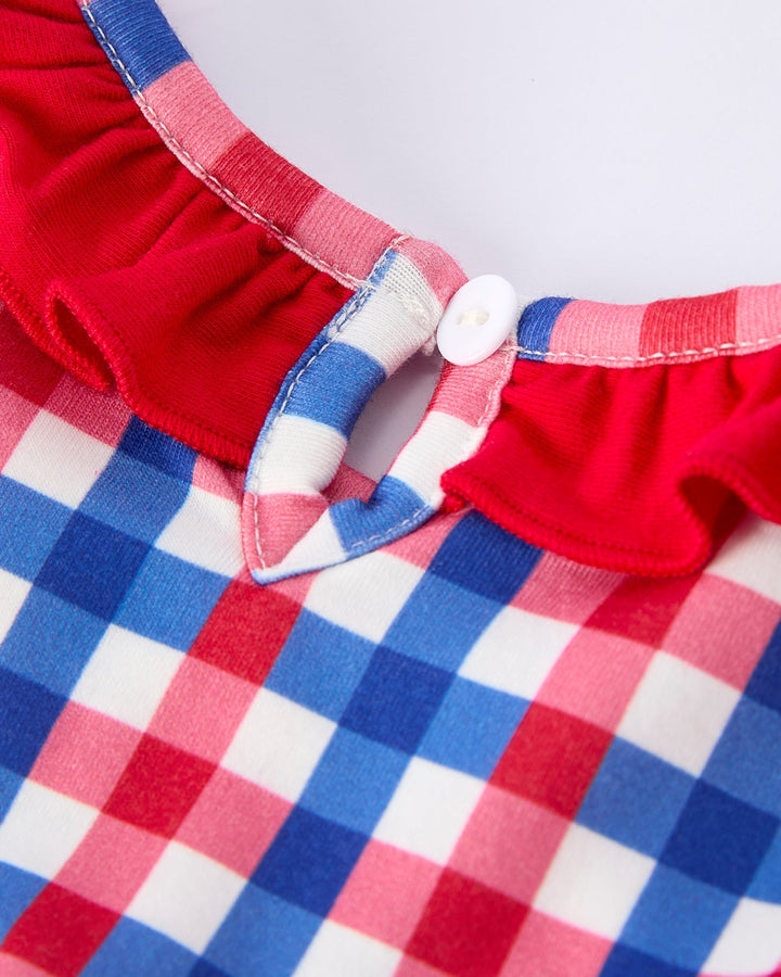 Close-up of a red, white, and blue checkered fabric with a button detail.