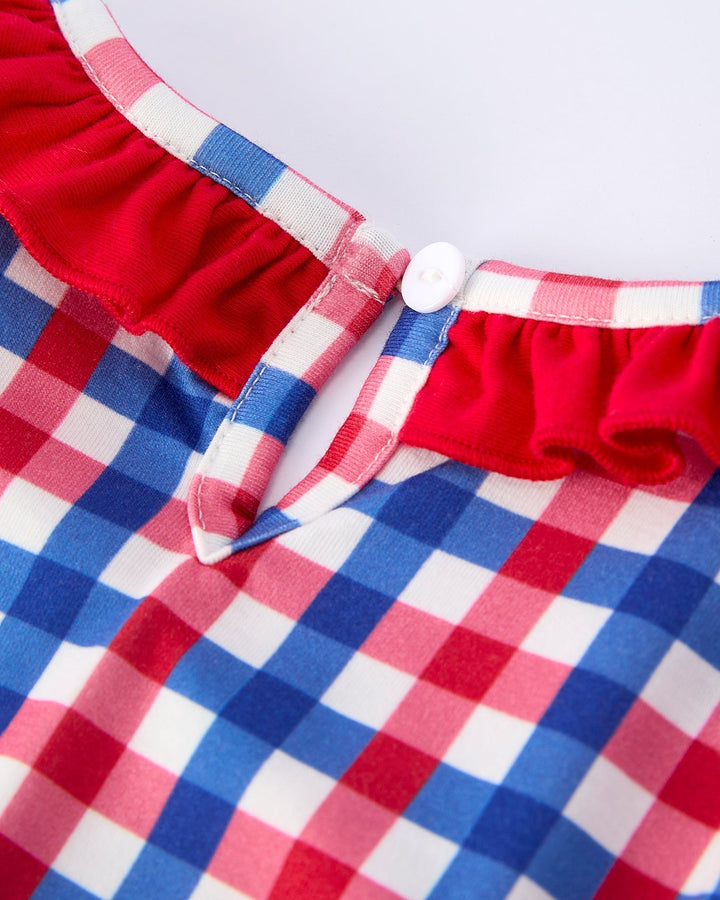 Close-up of a red, white, and blue checkered fabric with a button detail.
