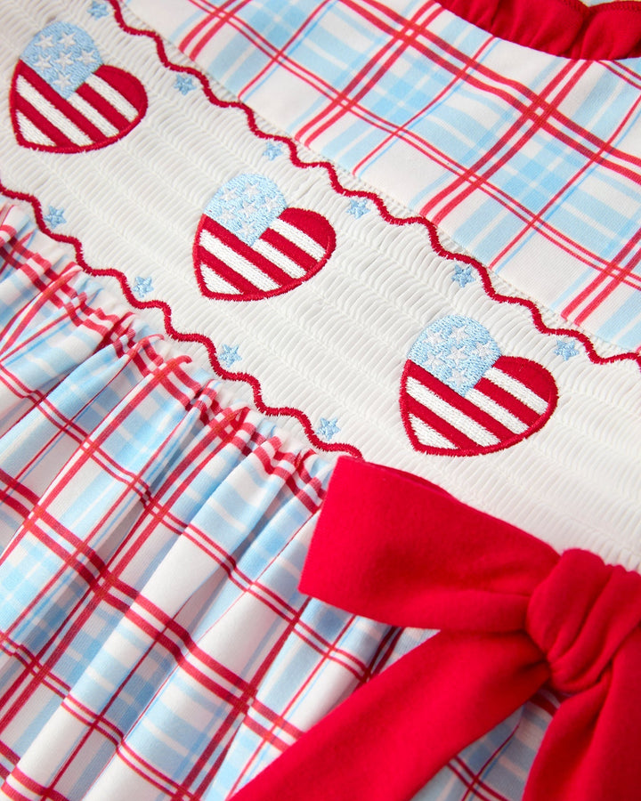 Close-up of a red, white, and blue fabric with heart patterns and plaid designs.