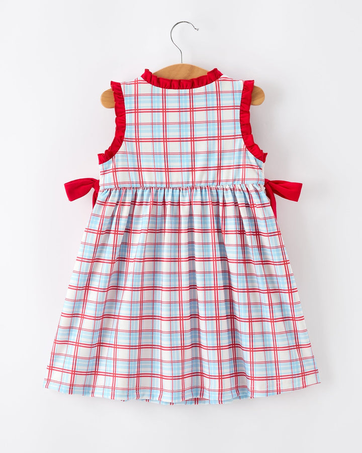 Plaid dress with red straps on a hanger against a white background