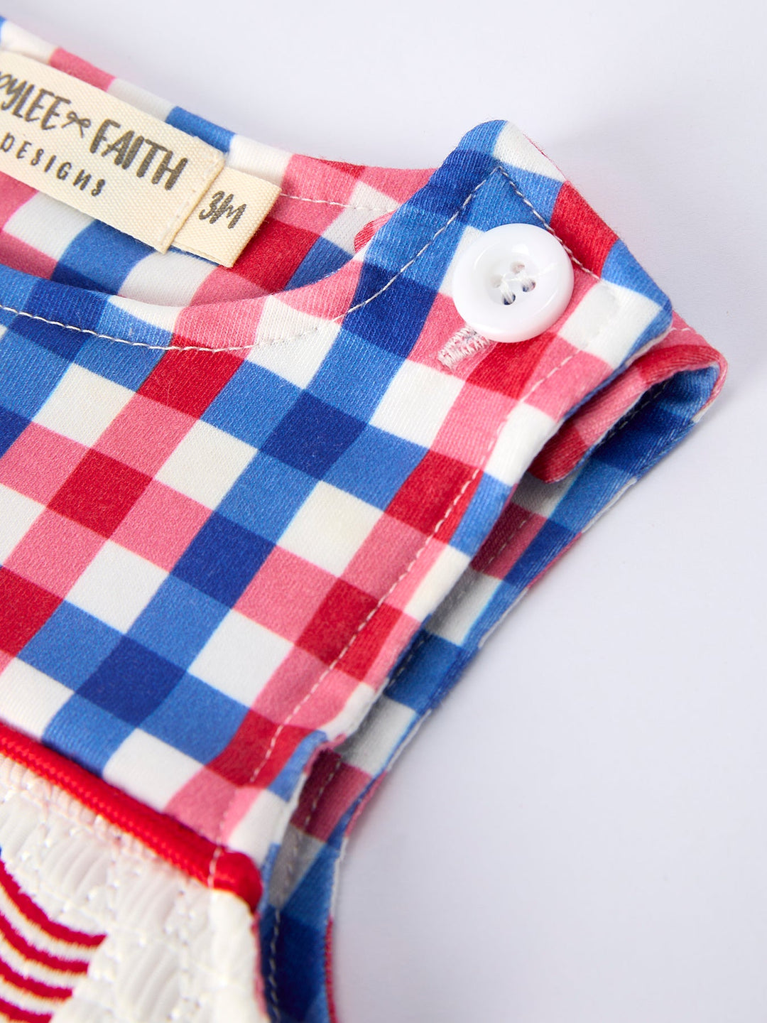 Red, white, and blue checkered fabric with a button and &
