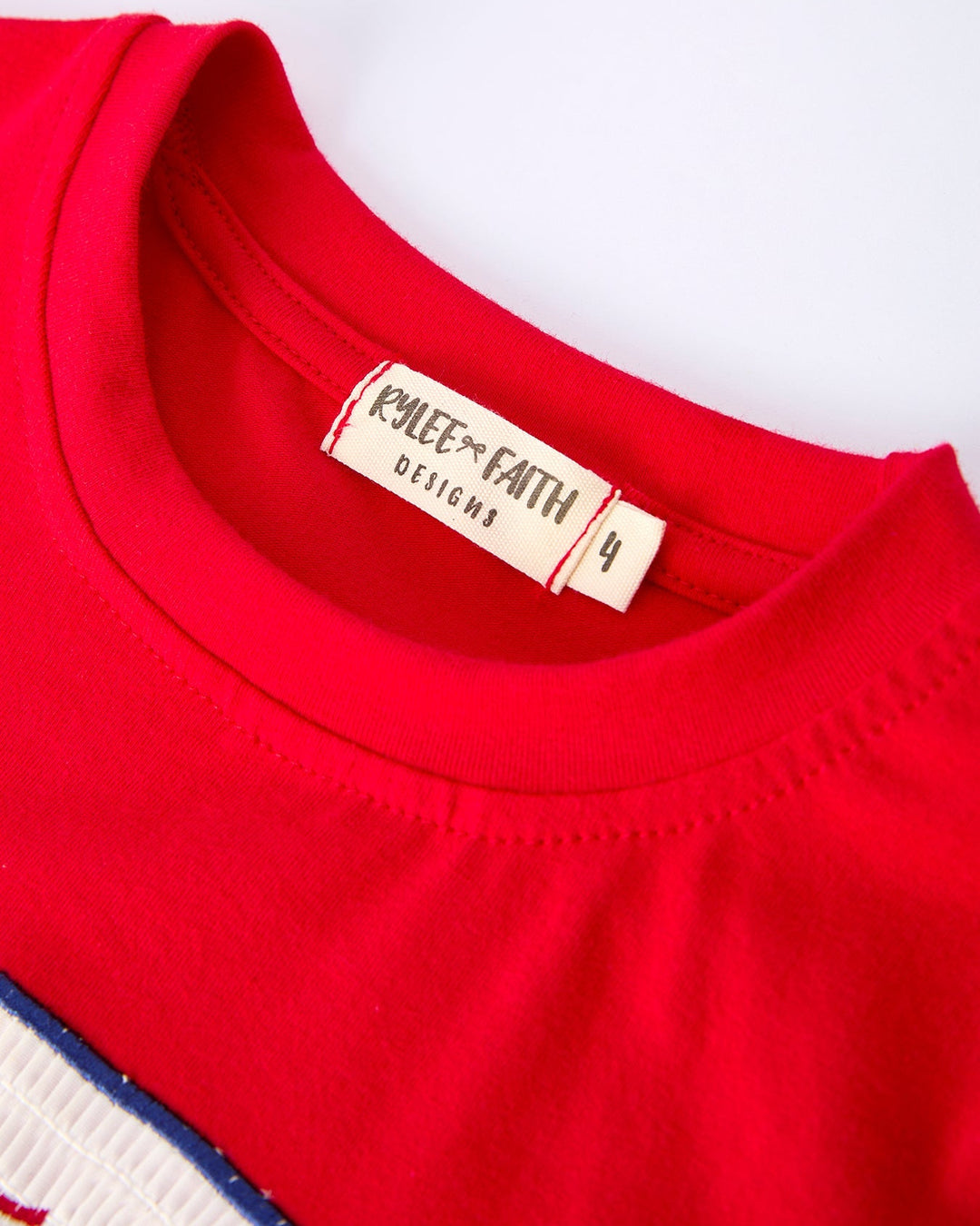 Close-up of a red garment with a brand label on a white background