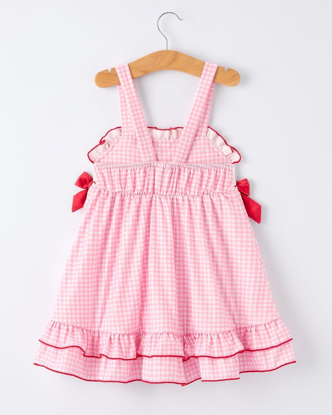 Pink checkered dress with ruffles on a white background