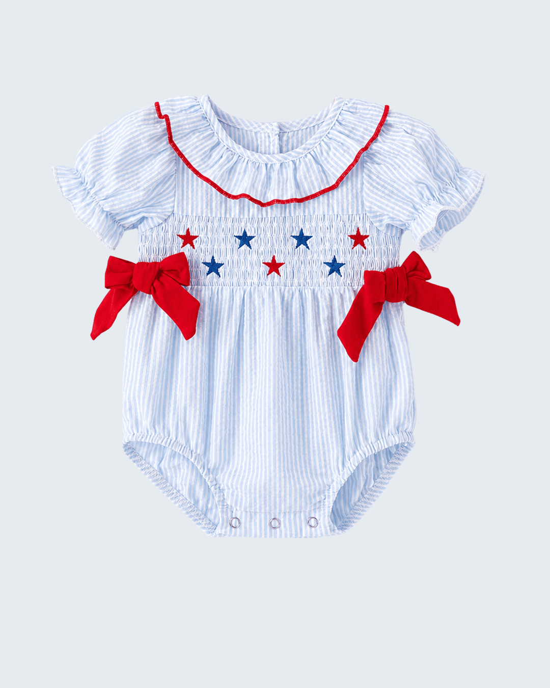 Baby romper with red bows and blue star patterns on a light gray background