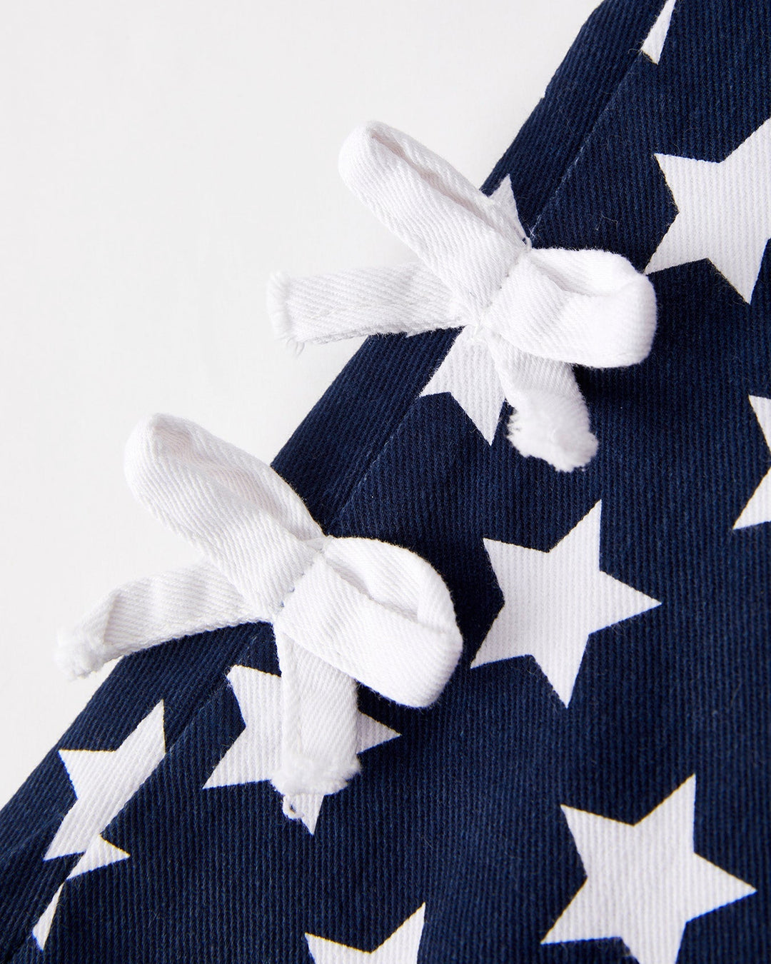 Navy blue fabric with white star pattern and white ribbons.
