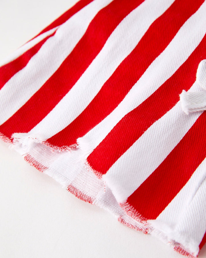Close-up of red and white striped fabric with frayed edges on a light background