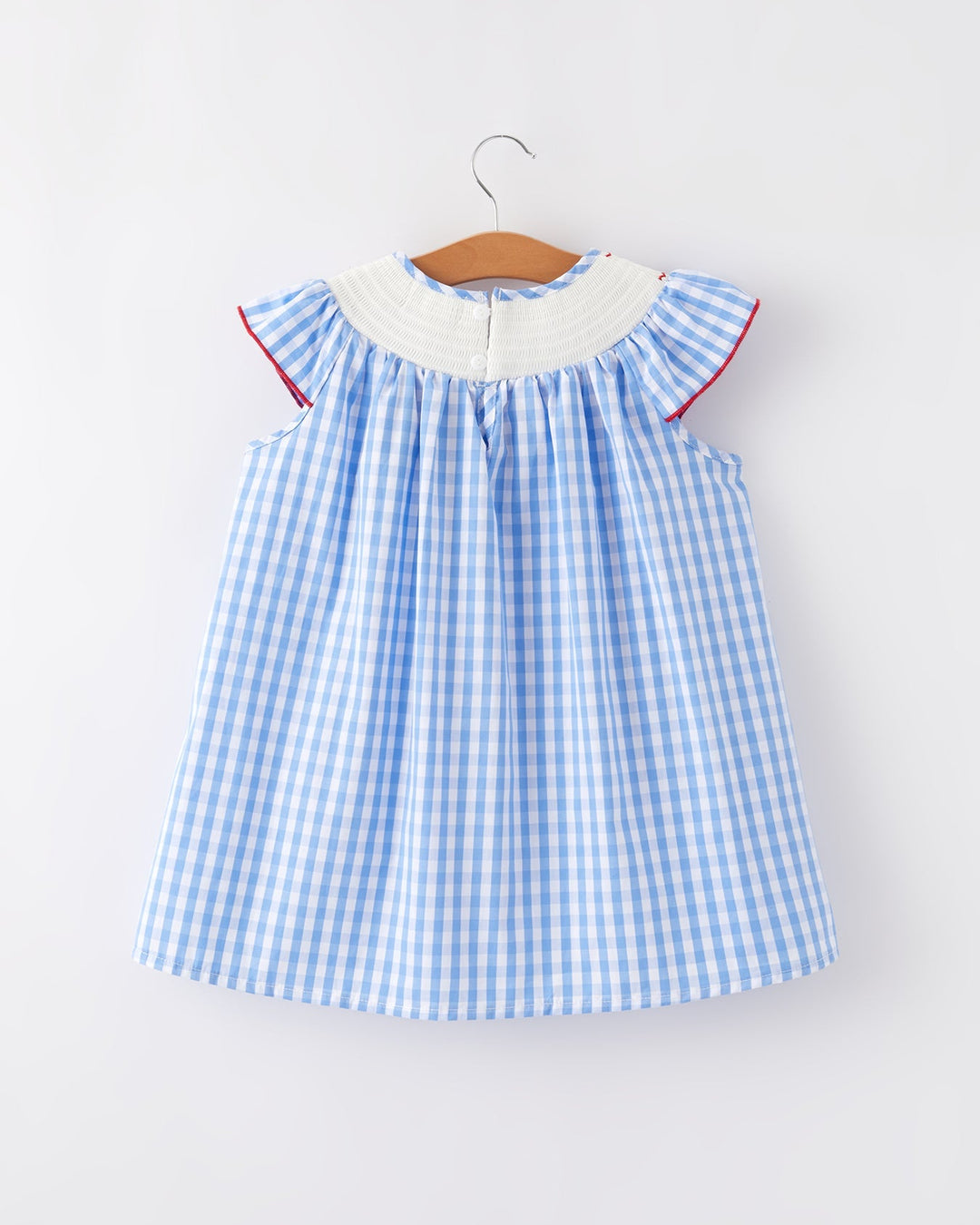 Blue gingham dress with white collar on a hanger against a white background