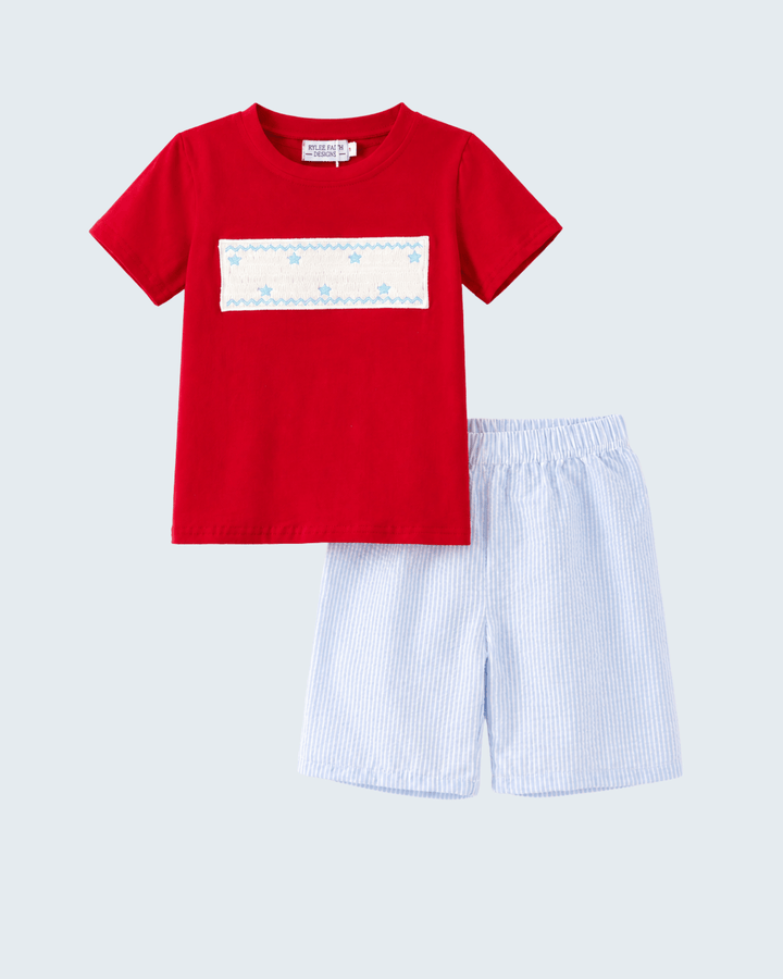 Red t-shirt with a white patch and blue shorts on a light gray background