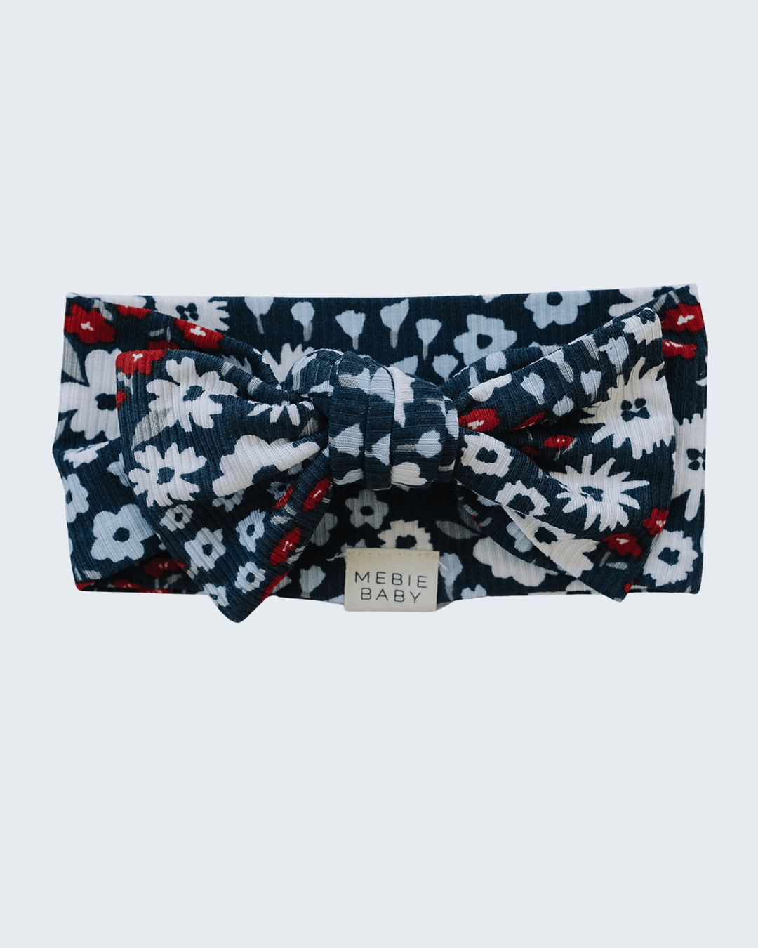 Floral ribbed bamboo head wrap with navy base, white flowers and red accents, knotted bow
