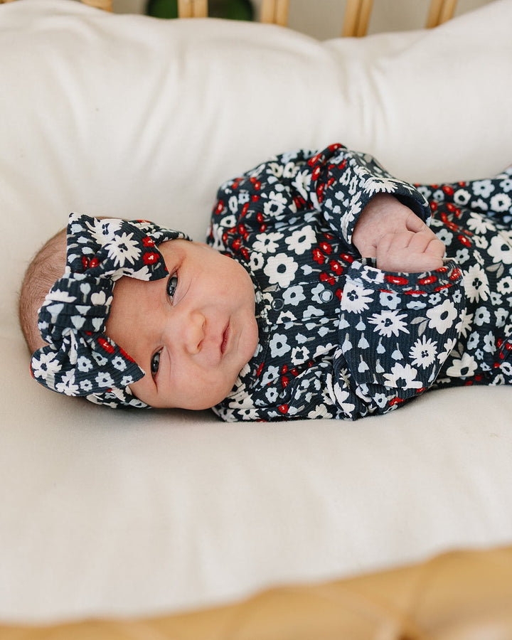 Infant wearing navy floral ribbed head wrap with tied bow; matching sleeves