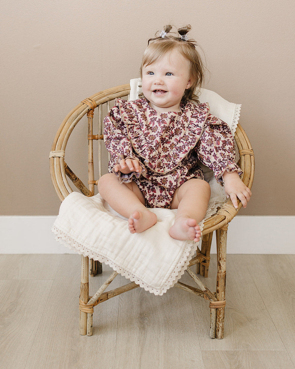 Maroon floral romper on baby with puff sleeves and gathered waist