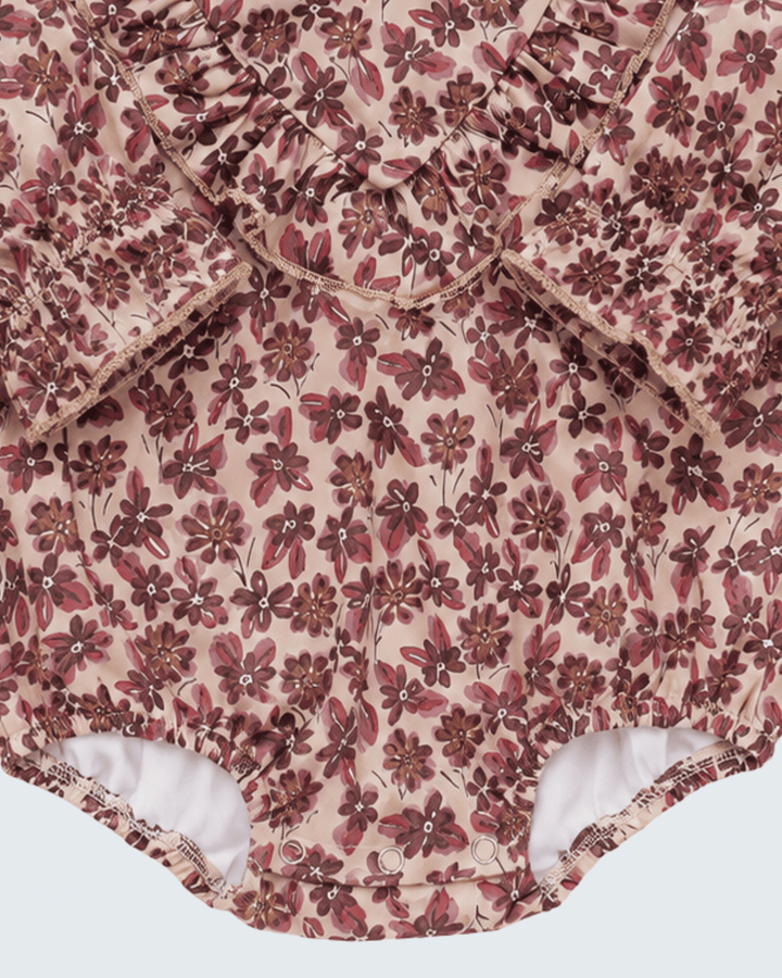 Pink floral bubble romper with gathered ruffle trim and elastic leg openings