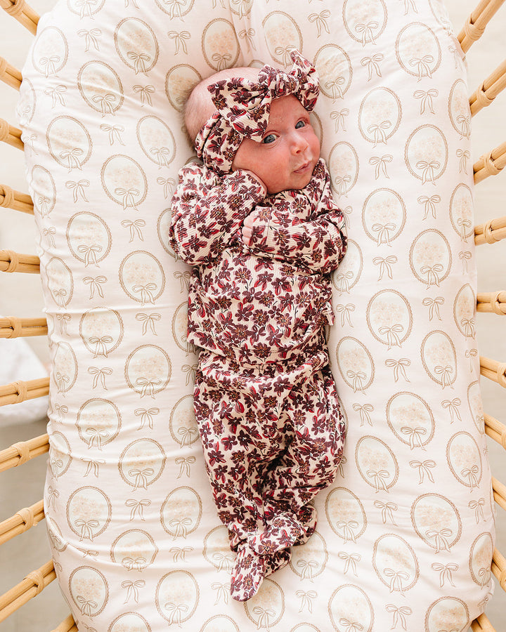 Maroon floral bamboo footed layette on baby: long-sleeve onesie and pants