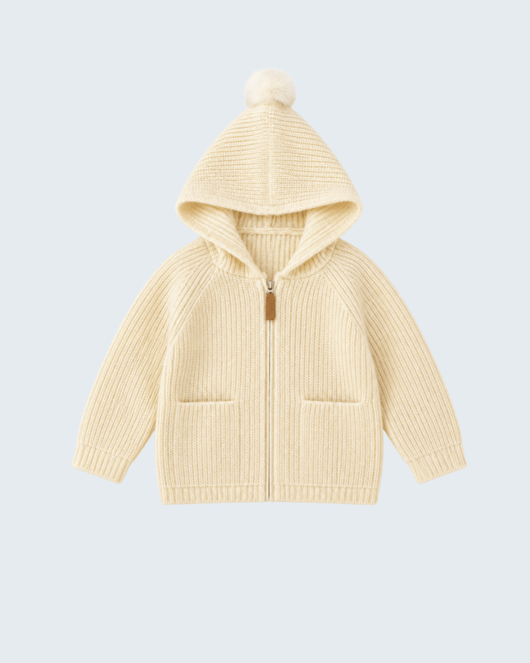 Cream knit hooded zip cardigan with pom-pom, front pockets, and ribbed cuffs