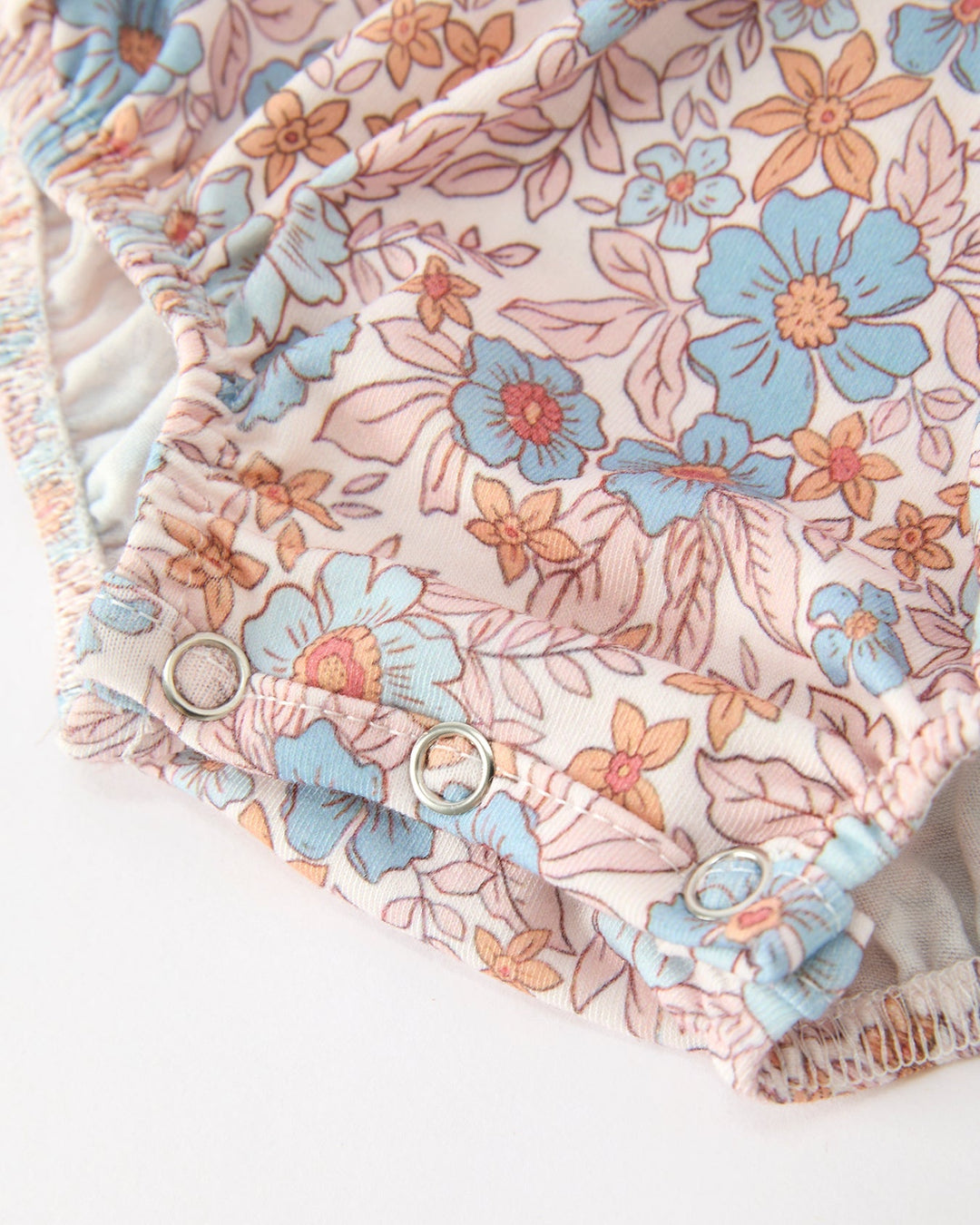 Floral baby romper with elastic cuffs and crotch snaps