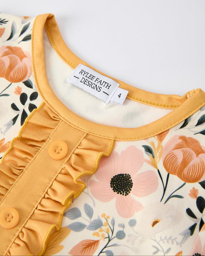 Girls pajama top neckline with tag label, orange button placket and floral fabric