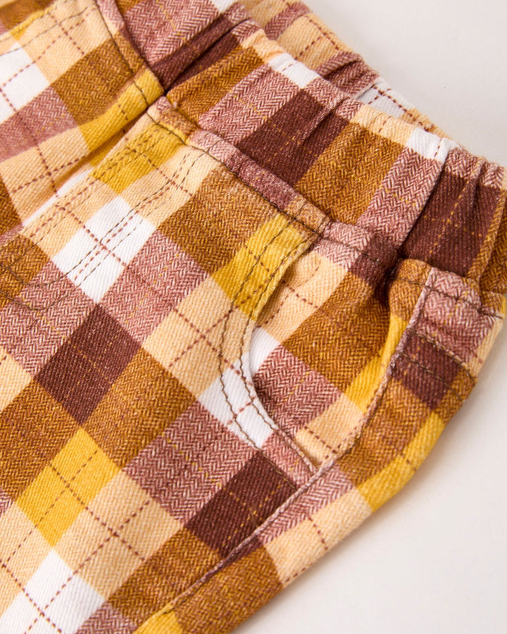 Plaid fabric trousers with gathered elastic waistband, close-up