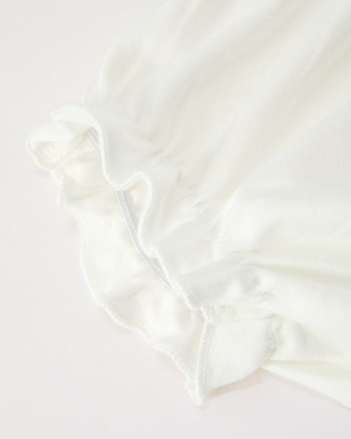 Cream baby bloomer shorts with ruffled cuffs and gathered elastic waist