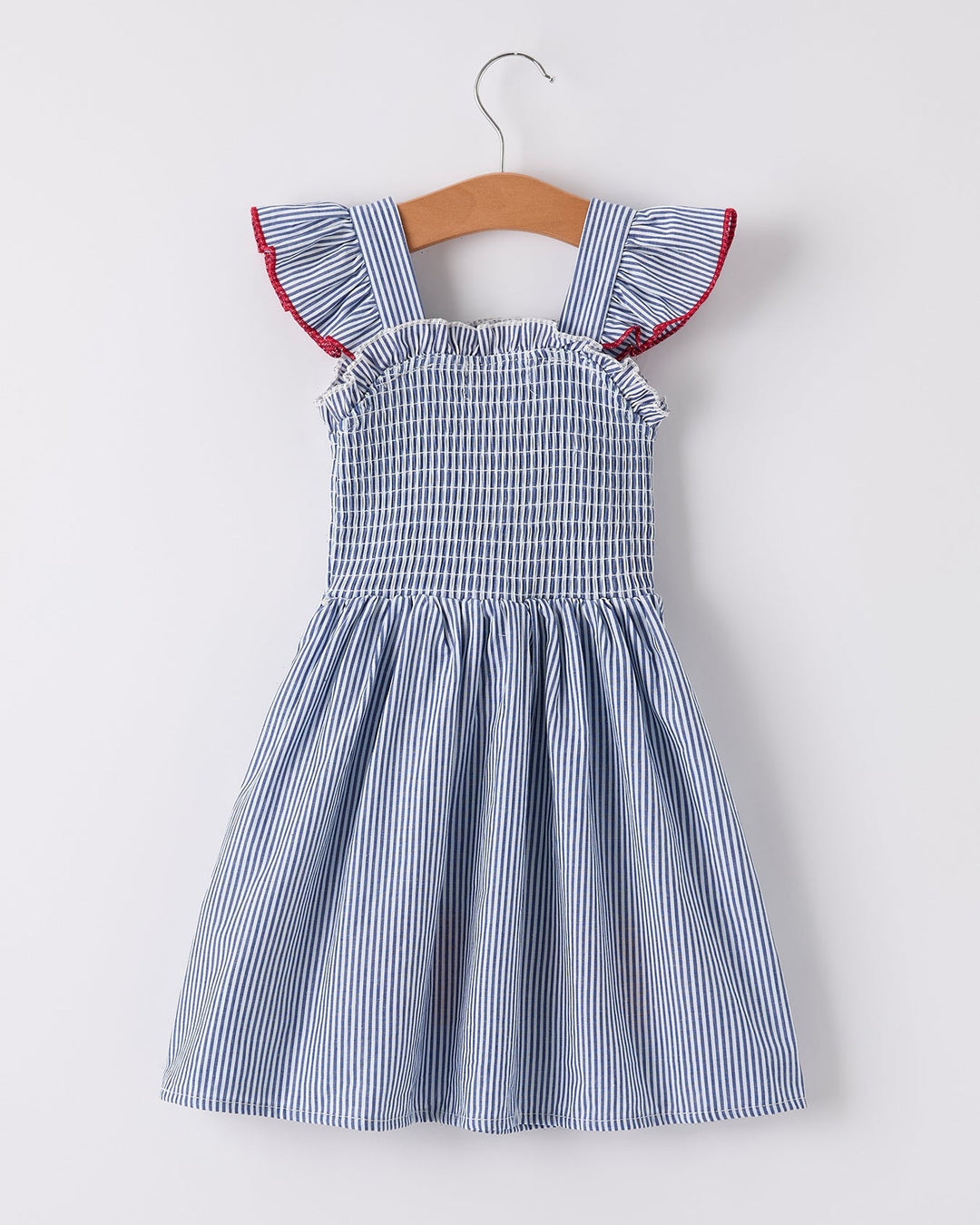 Blue and white striped dress with red accents on a hanger against a white background