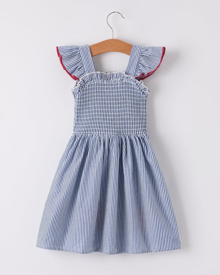 Blue and white striped dress with red accents on a hanger against a white background