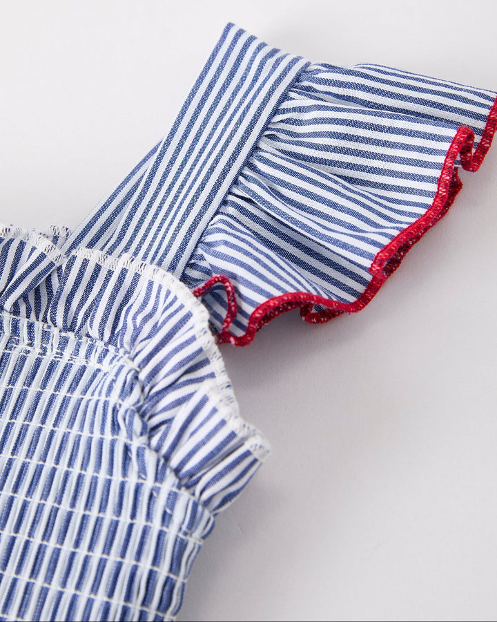 Blue and white striped dress with red trim on a light gray background
