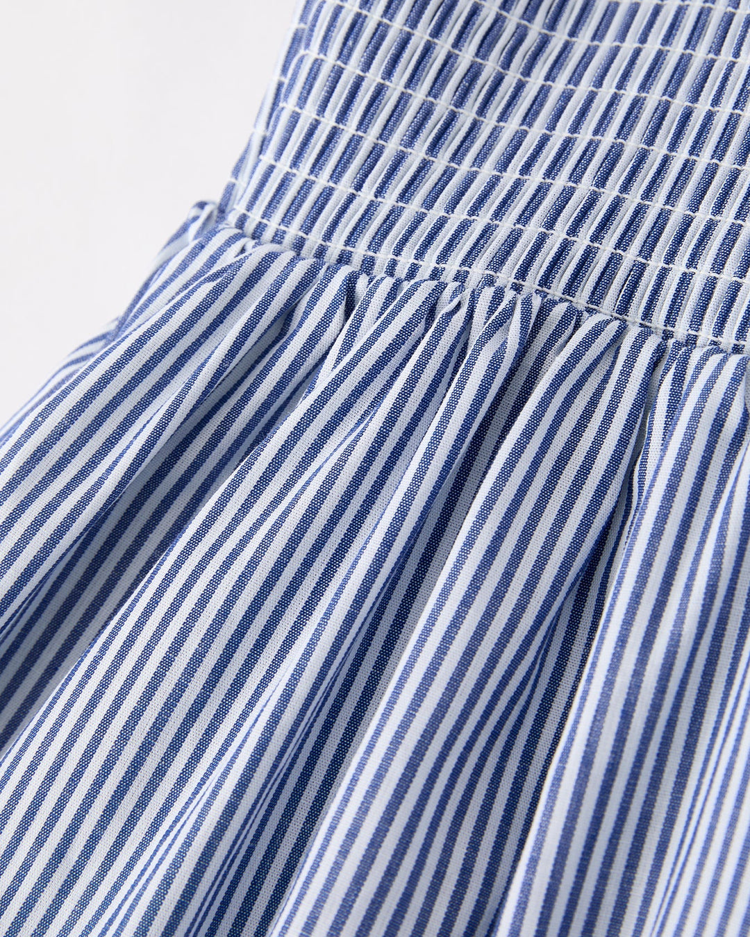 Close-up of a blue and white striped dress with a plain background
