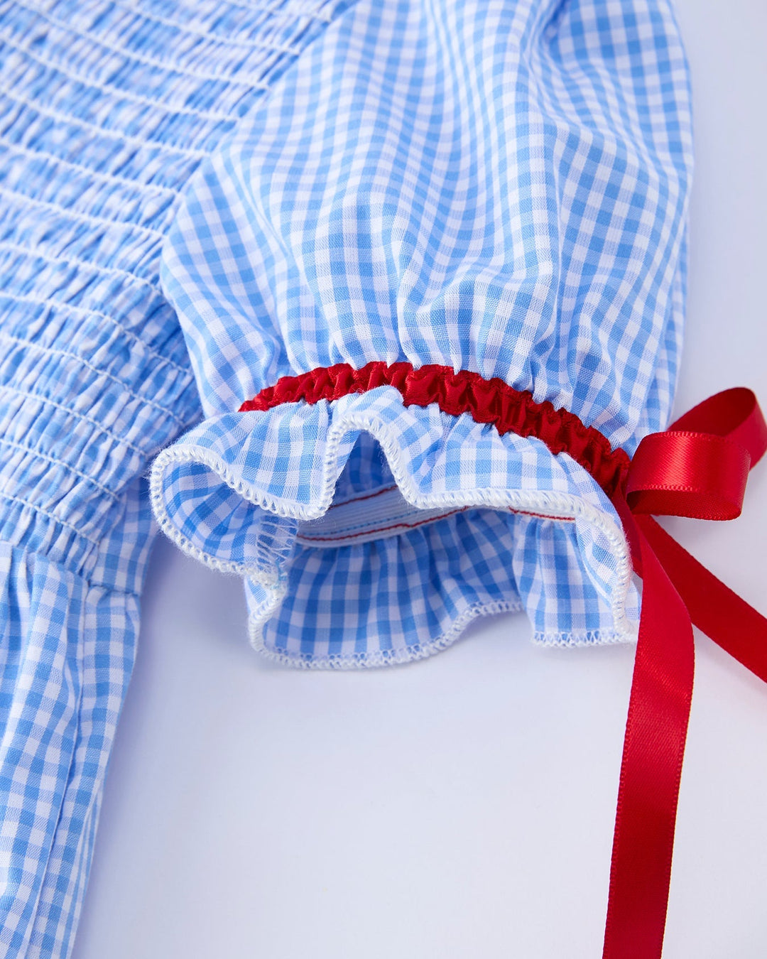 Blue checkered dress with red ribbon on a white background