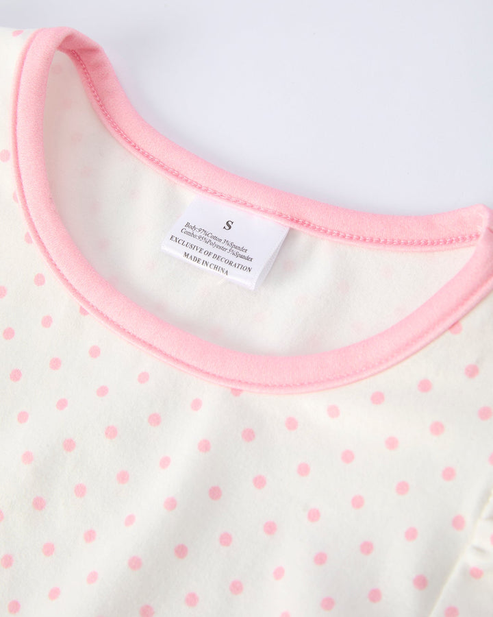 Close-up of a baby outfit with pink polka dots and a pink neckline on a white background.