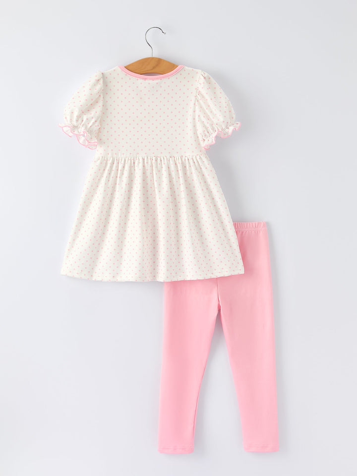 White dress with pink trim and pink leggings on a white background