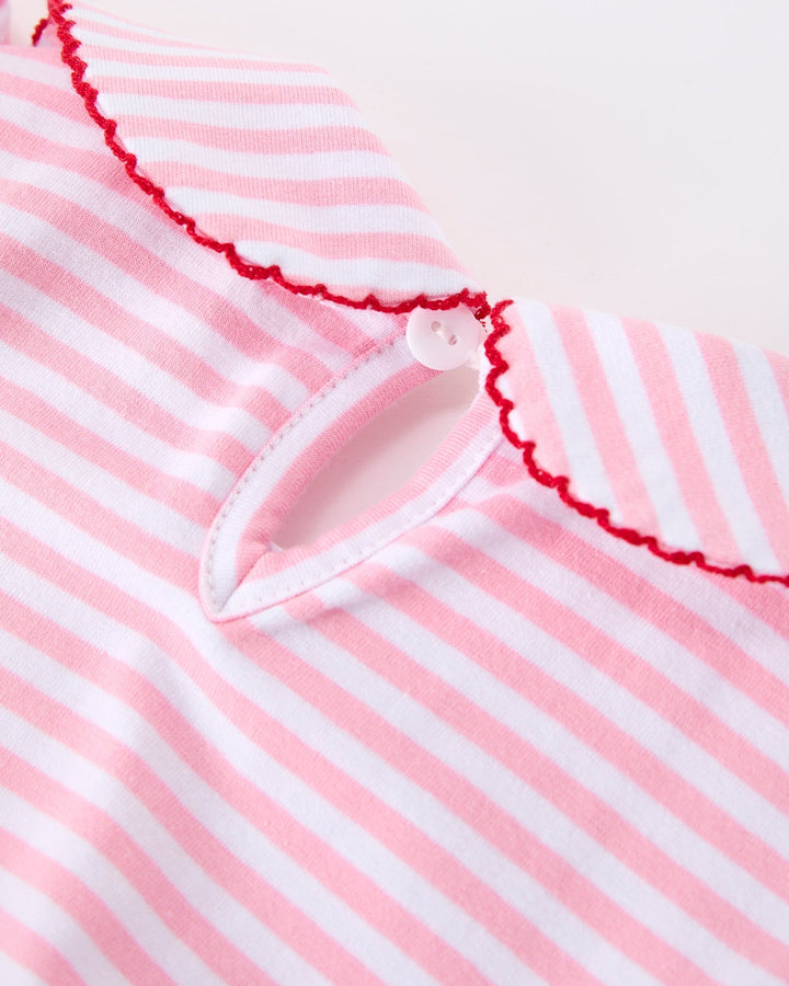 Close-up of a pink and white striped garment with a scalloped edge.